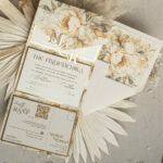 Ivory Elegance: Wedding Invitations with Golden Initials Seal, 3-Fold Sophistication and Floral Envelope for a Touch of Glamour
