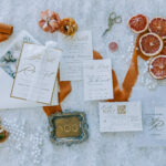 Essentials for a Picturesque, Dreamy, and Elegant Wedding Celebration: Ivory Elegance with Pearls and Vibrant Orange Accents