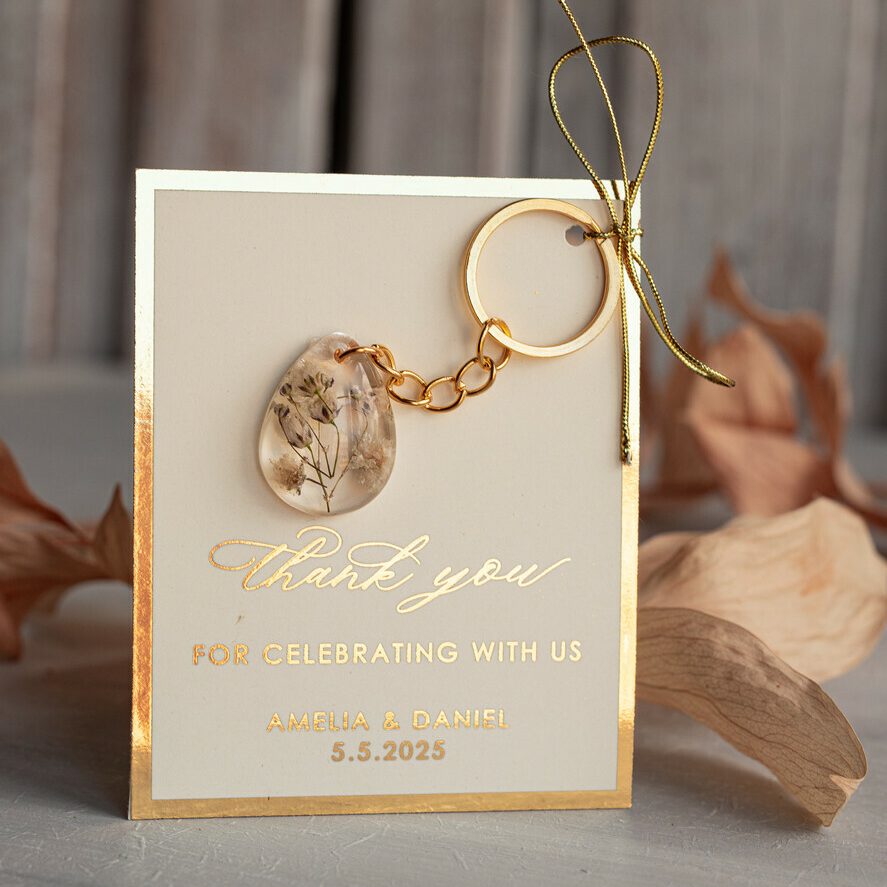 Gold Keychain Wedding Favors: Teardrop Design with White Flowers and Ivory Thank You Card